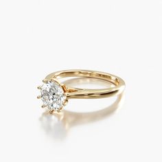 a yellow gold engagement ring with a single diamond in the center, on a white background