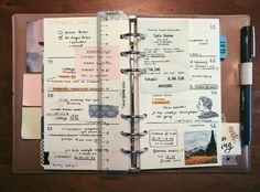 an open planner with notes and pens on it