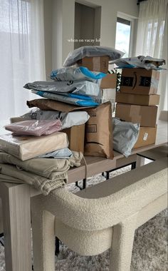 a pile of boxes sitting on top of a table next to a bench in a living room