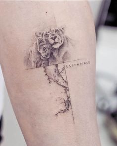 a woman's thigh with a lion and map tattoo on the side of her leg