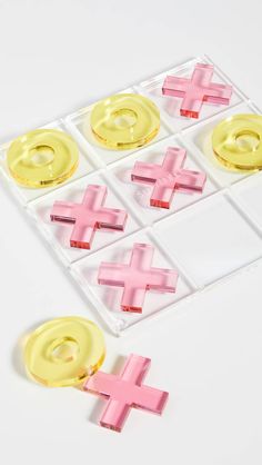 pink and yellow crosses are placed on top of each other in the shape of buttons