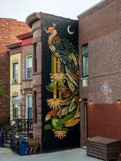 a mural on the side of a building with a bird painted on it's door