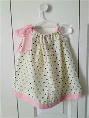 a polka dot skirt hanging on a white door with a pink bow at the top