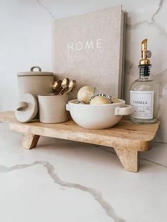 a wooden shelf with bowls and bottles on it next to a sign that says home