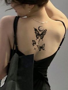 the back of a woman's shoulder with butterfly tattoos on her upper and lower arm