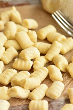 a pile of uncooked dough sitting on top of a table next to a fork