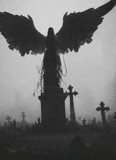 an angel statue surrounded by tombstones and crosses