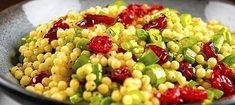 corn salad with cranberries and green onions in a bowl