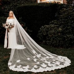 a woman in a wedding dress and veil posing for the camera with flowers on her bouquet