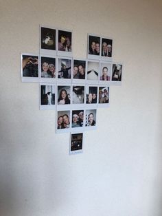 a heart shaped wall hanging on the side of a white wall with many photos attached to it