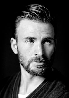 a black and white photo of a man with a goatee hairstyle looking at the camera