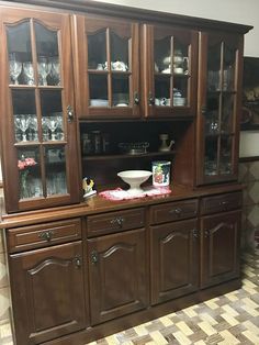 a large wooden china cabinet with glass doors