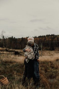 an older couple hugging in the middle of a field