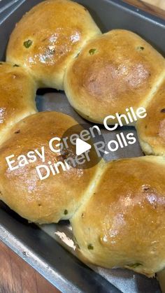 four rolls in a baking pan with green chili paste on top and the words easy green chili dinner rolls below