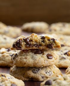 chocolate chip cookies stacked on top of each other with one cookie broken in the middle