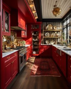 a kitchen with red cabinets and white counter tops, along with a rug on the floor