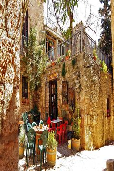 an old stone building with tables and chairs outside