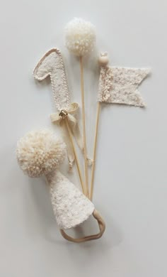 three white knitted items with bows on them