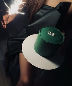 a woman holding a green hat and sparkler