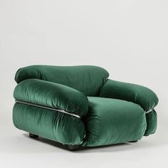 a green reclining chair sitting on top of a white floor