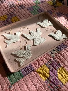 a tray that has leaves on it sitting on a quilted tablecloth with scissors and thread