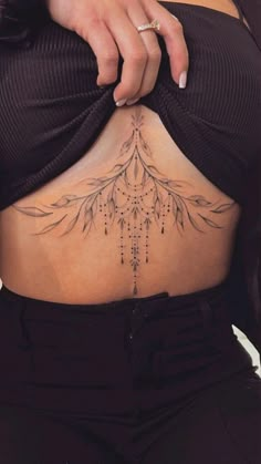 a woman's stomach with an intricate tattoo on her belly and the bottom part of her lower back