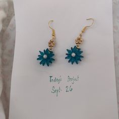 a pair of blue and gold flower earrings on top of a white card with the words today's price