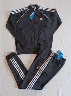 This listing is for a New  Men's Adidas Originals Primeblue Superstar Tracksuit Jacket: Regular fit Ribbed collar 60% recycled polyester, 40% cotton interlock Heavyweight fabric Classic adidas track jacket Front zip pockets Ribbed cuffs and hem Pants: Slim fit Elastic waist with drawcord 60% recycled polyester, 40% cotton interlock Heavyweight fabric Tapered track pants Front zip pockets Ribbed cuffs Tapered legs Color: Black/White Size: Men’s US Medium Condition: New with tags..100% Authentic.. White Tracksuit Outfit, Adidas Tracksuit Mens, White Tracksuit, Tracksuit Outfit, Classic Adidas, Tracksuit Men, Hem Pants, Adidas Tracksuit, Men Fashion Casual Shirts