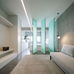 a living room filled with white furniture and walls covered in frosted glass partitions