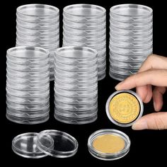 a person is holding a coin in front of some plastic cups with lids on them