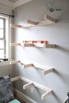 three wooden shelves mounted to the wall in a room with a baby's photo on it