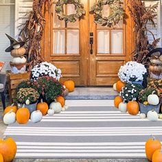 pumpkins and gourds are arranged on the front porch for fall decorating