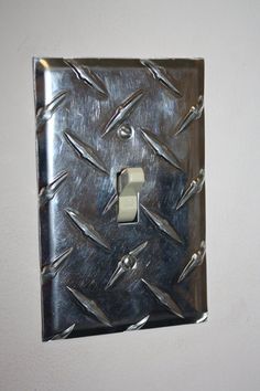 a metal light switch cover sitting on top of a white wall