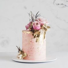 a pink cake decorated with flowers on top of a white countertop next to an instagram post