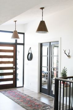 an entry way with two doors and a rug on the floor