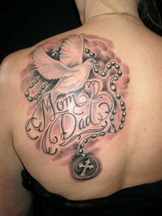 the back of a woman's shoulder with a rosary and dove