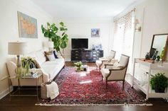 a living room filled with furniture and a rug on the floor in front of a tv