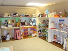 a doll house filled with lots of furniture and dolls on the shelves next to each other