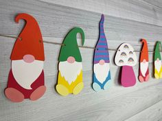 colorful paper gnomes are hanging on the wall