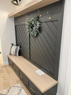 a wooden bench sitting in front of a wall with a wreath on top of it