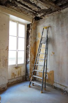 a ladder leaning against a wall in an unfinished room