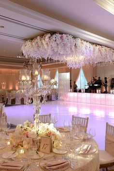 a table set up for an event with flowers on the centerpiece and place settings