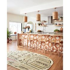 a kitchen filled with lots of counter top space next to a wooden floor covered in potted plants