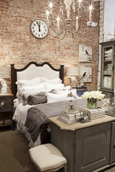 a bed room with a neatly made bed next to a dresser and a clock on the wall