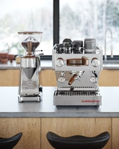 an espresso machine sitting on top of a counter next to a coffee maker