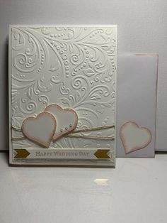 two hearts on a white card with gold trimmings and an envelope that says happy wedding day