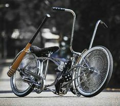 an old bicycle with a wooden handlebar is parked on the side of the road