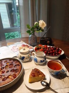 a table topped with plates and bowls filled with food next to a bowl of fruit