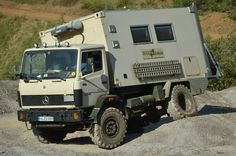 an army truck is parked on the side of a hill