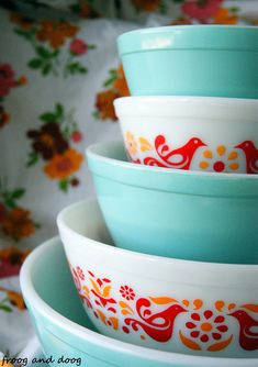 three bowls stacked on top of each other in front of a flowered table cloth